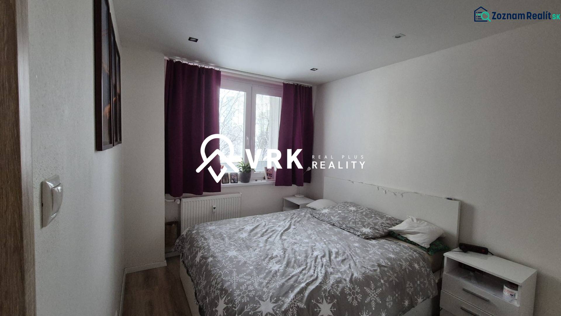 Bedroom in a 2-room apartment with a bed, nightstands, and curtains in dark colors.