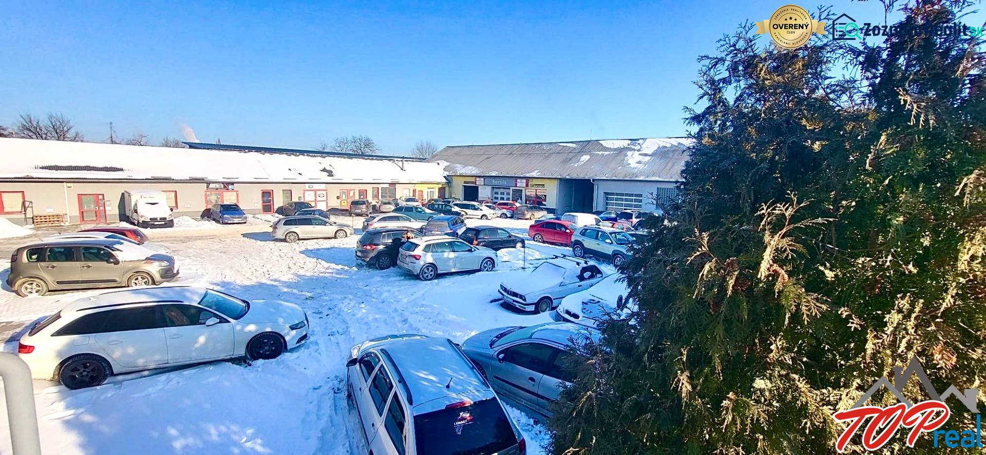 A snowy parking lot full of cars in front of the offices on Osloboditeľov in Košice - the Barca district.