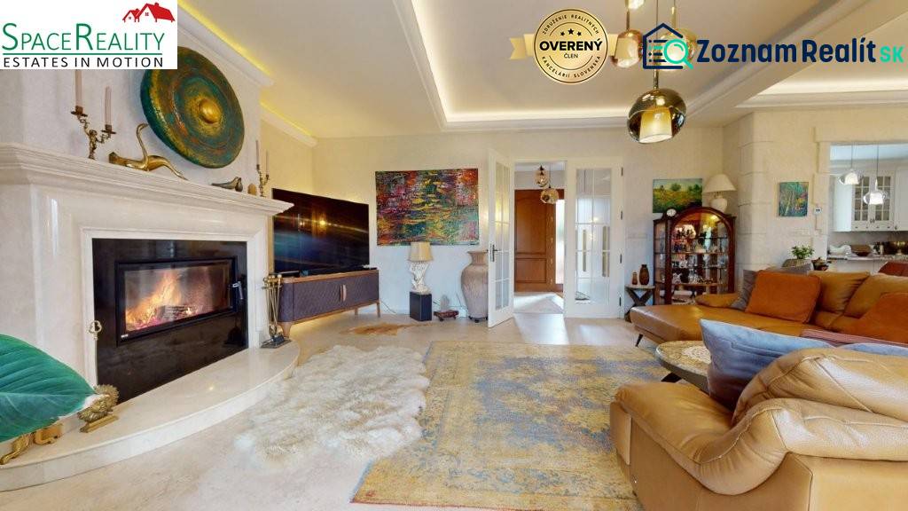Living room of a family house with a fireplace, comfortable sofa, and decorative artworks.