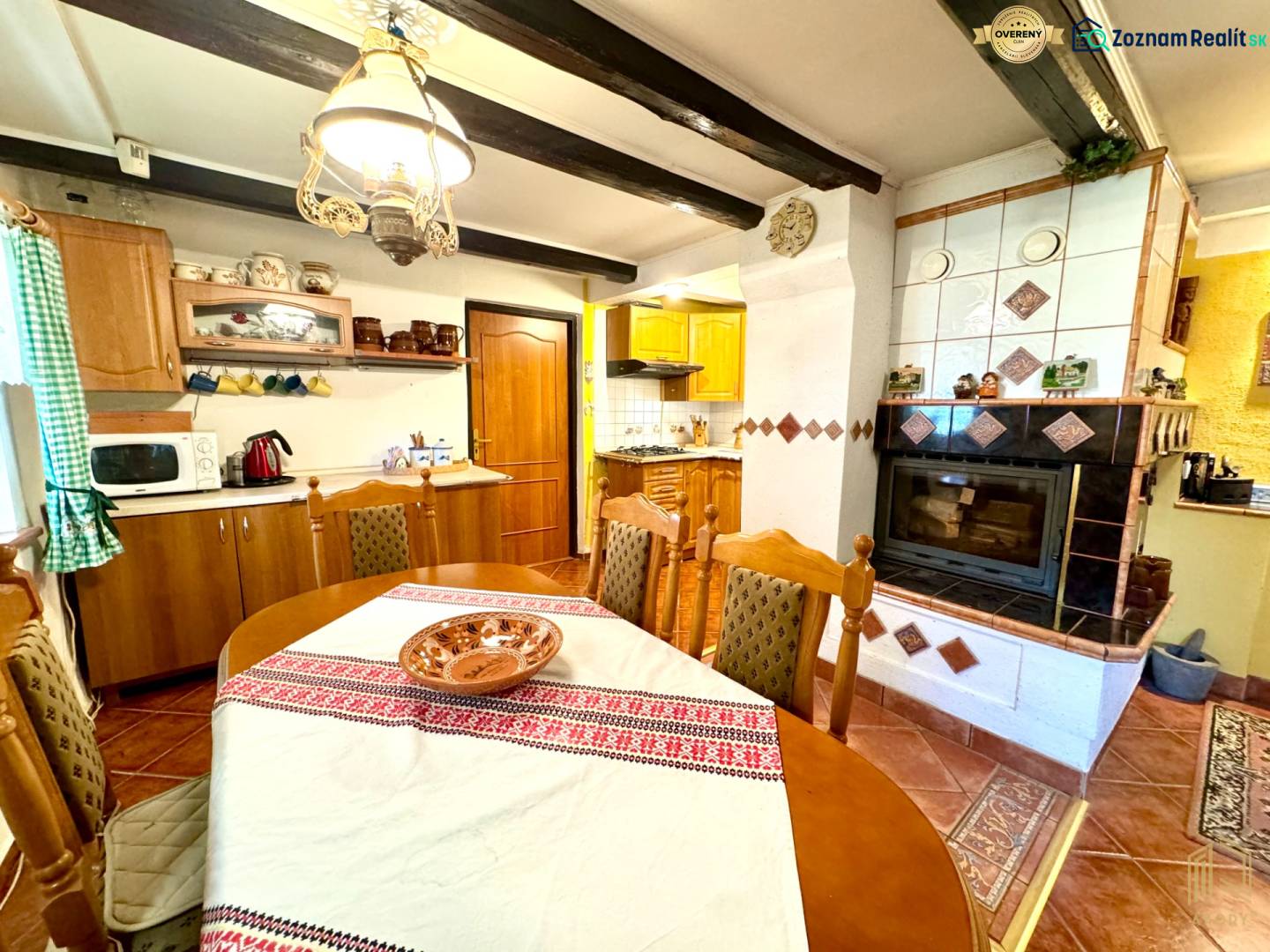 A kitchen in a family house with a stove, fireplace, wooden furniture, and decorative placemats.