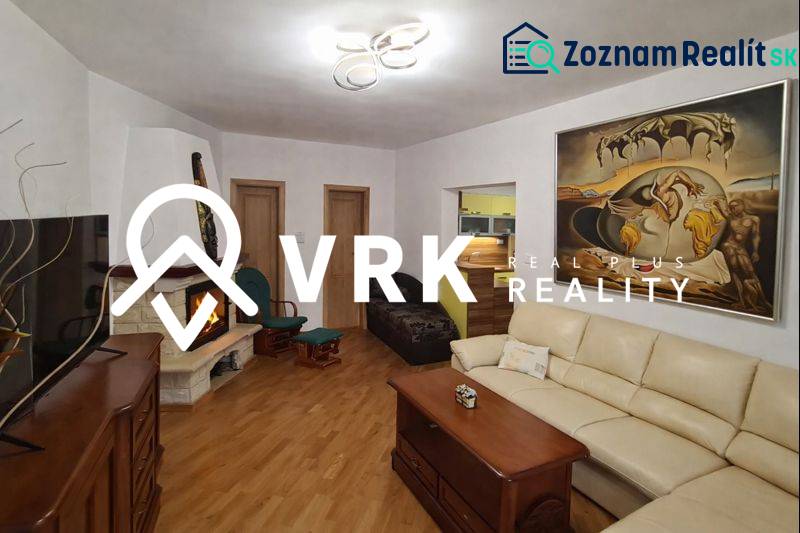 Living room in a 3-room apartment with a fireplace, sofa, and wooden decor flooring.