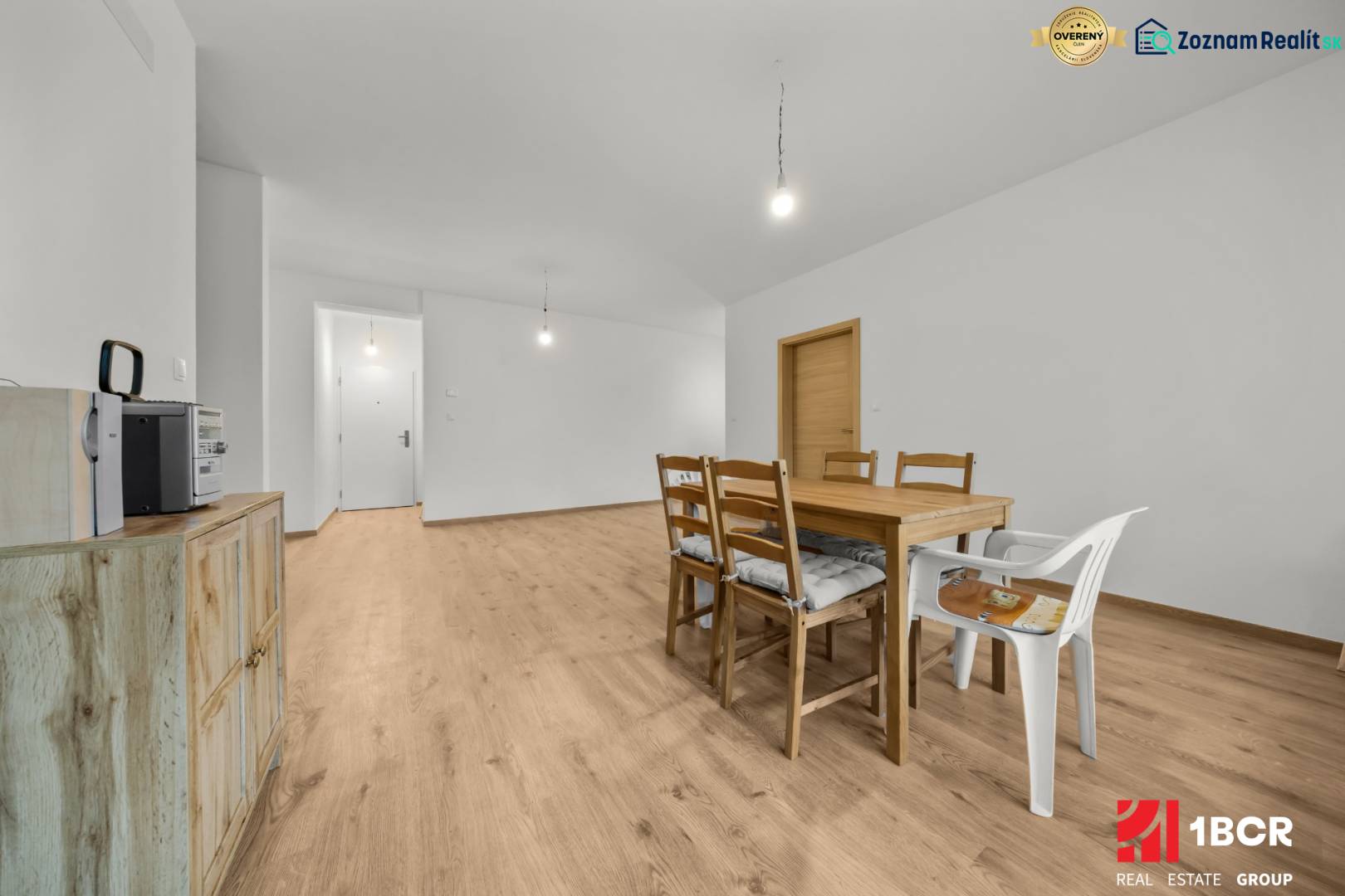 Dining room with a wooden table and chairs, floor with wooden decor, 3-room apartment.