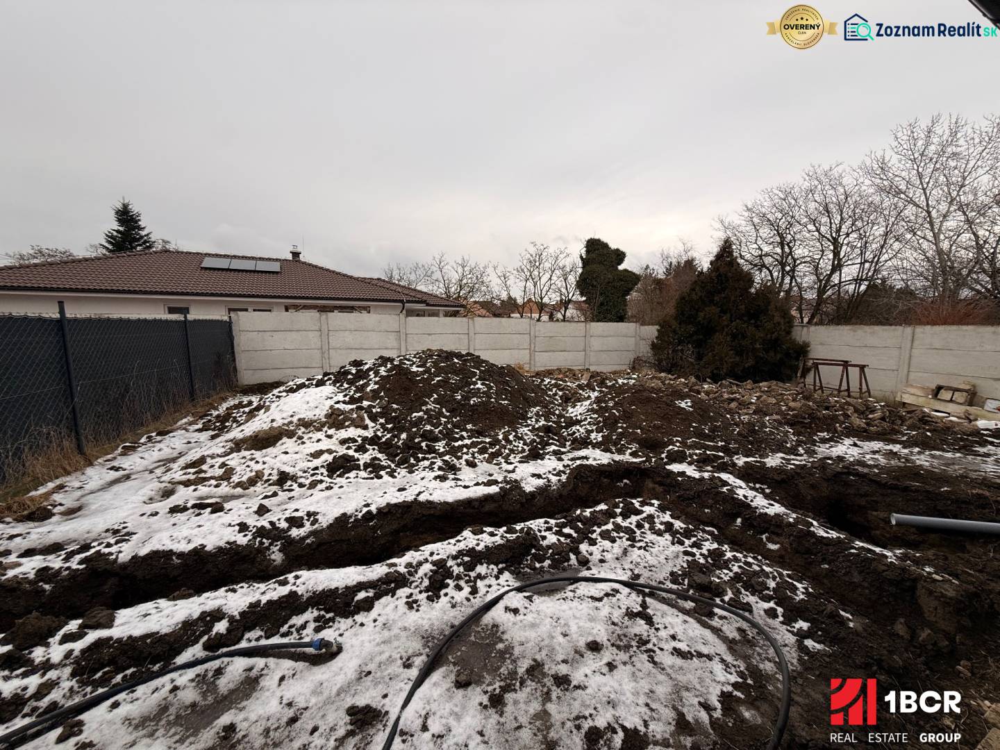 A snow-covered building plot near a family house in Veľký Grob.