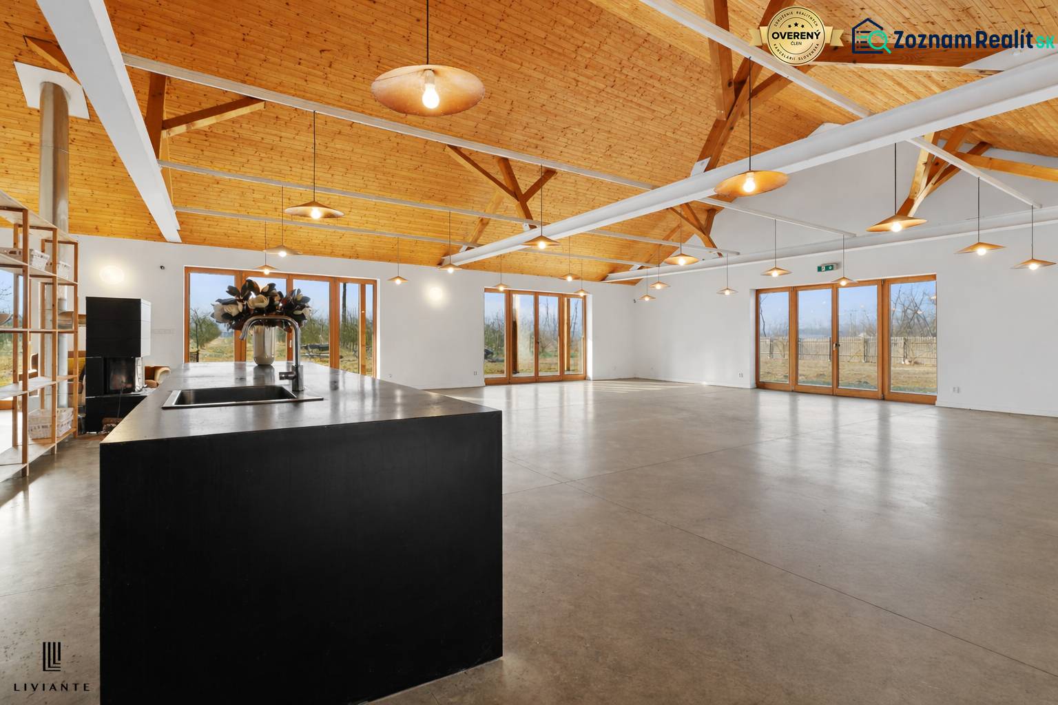 A building with large windows, high ceilings, and wood-patterned flooring.