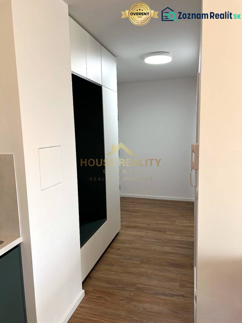 The 2-room apartment has a wooden decor floor, built-in wardrobes, and white walls.