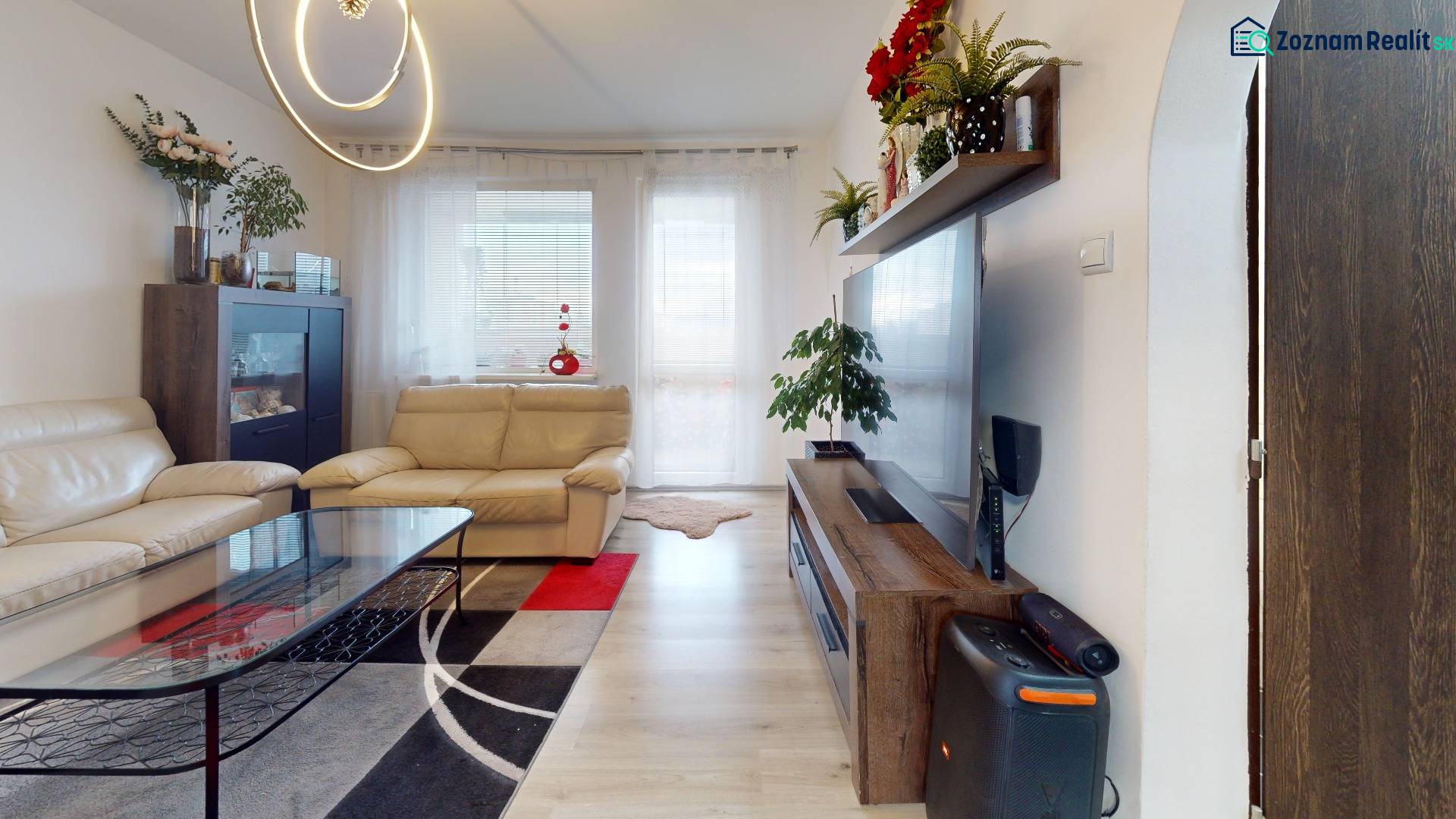 Living room in a 3-room apartment with cream furniture and wooden decor flooring.