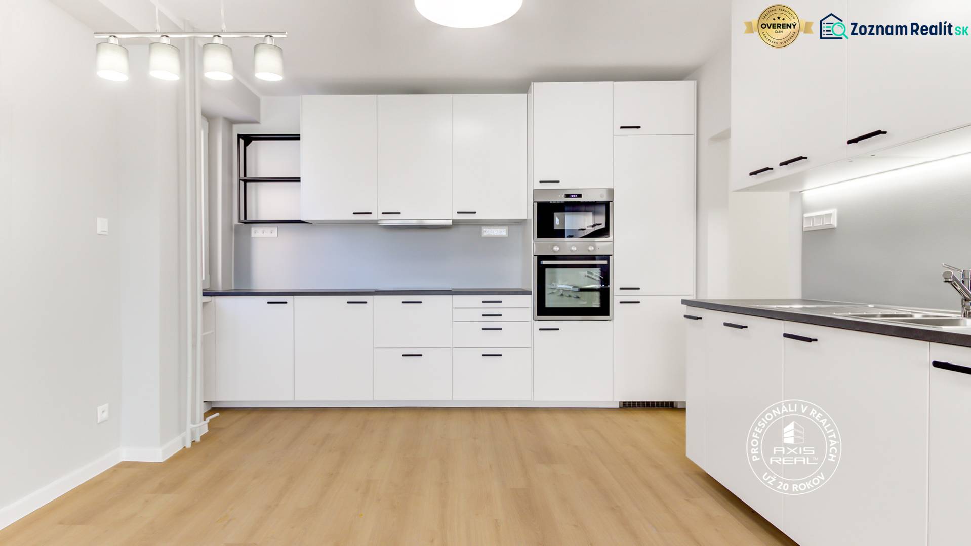 A kitchen in a 3-room apartment with white cabinets and a wood-patterned floor.