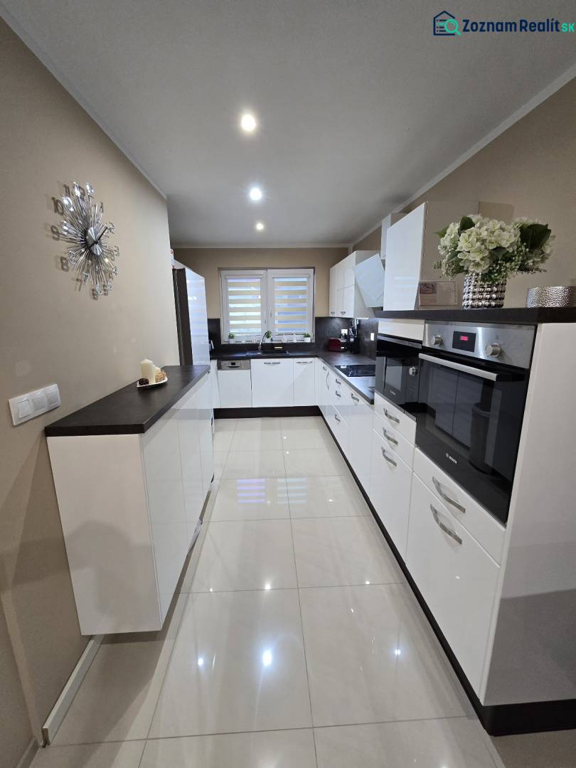 A kitchen in a family house with white cabinets, built-in appliances, and decorative accessories.