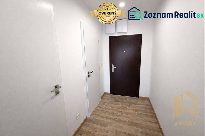 Entrance area in a studio apartment with doors and flooring featuring a wood design.