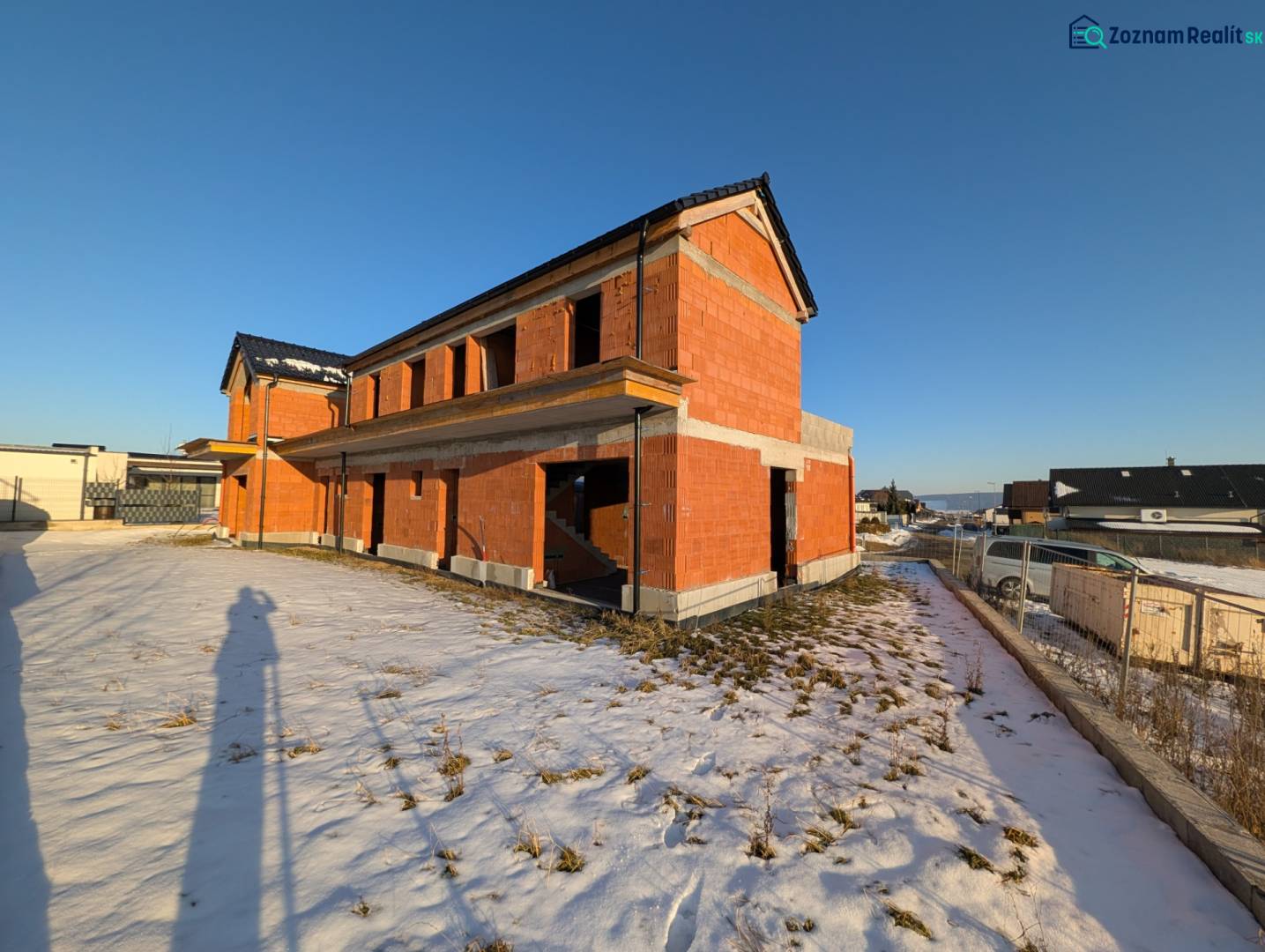 A family house in Mlynica during construction, surrounded by snow in a winter setting.