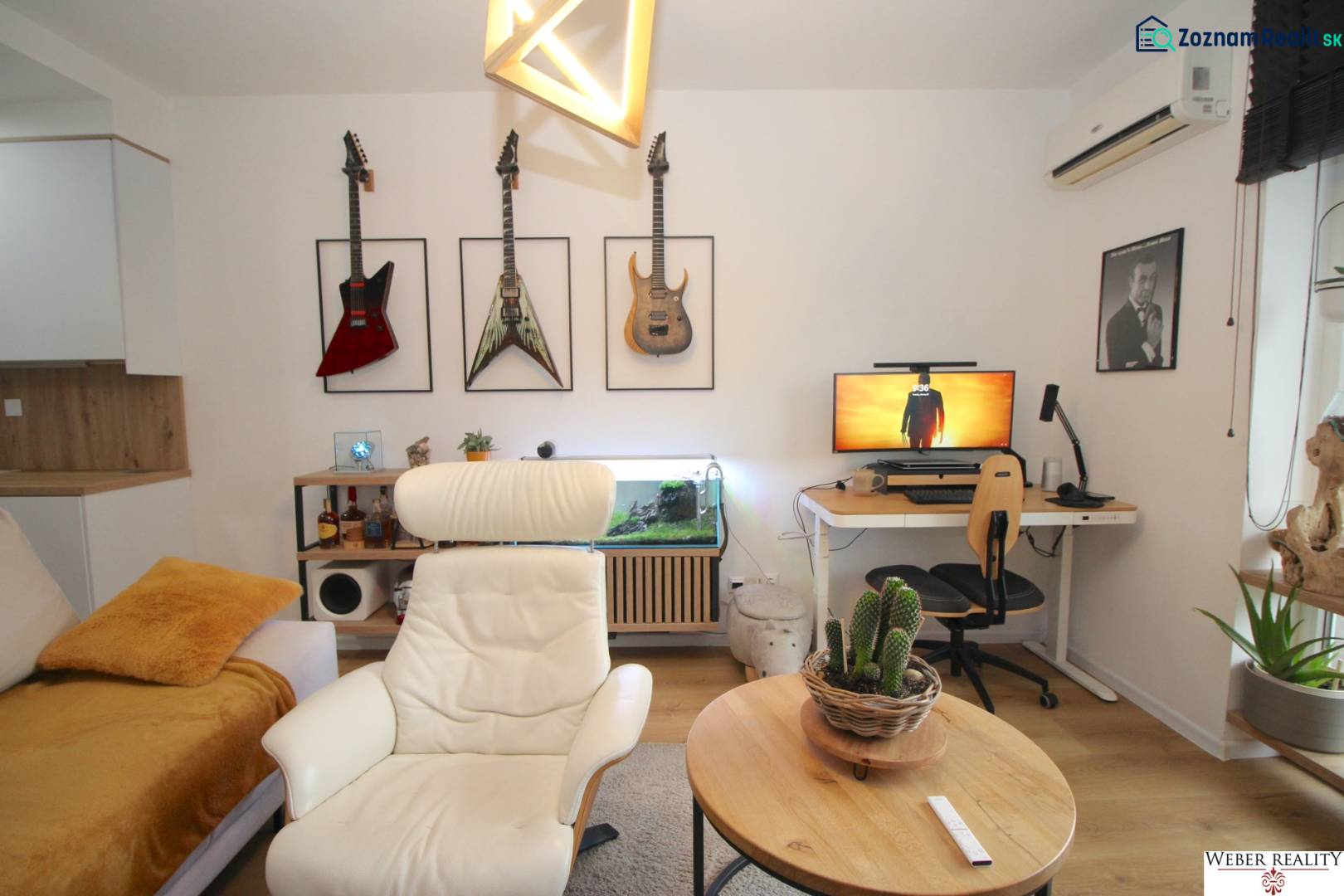 Living room with a sofa, armchair, desk, and guitars in a 2-room apartment.
