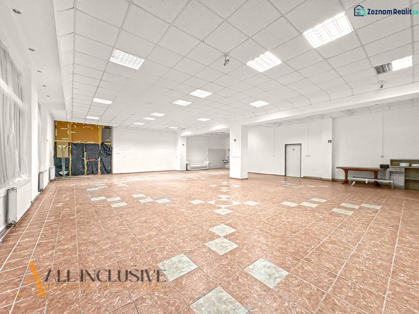 Spacious commercial premises with tiled floors and white walls, suitable for various uses.