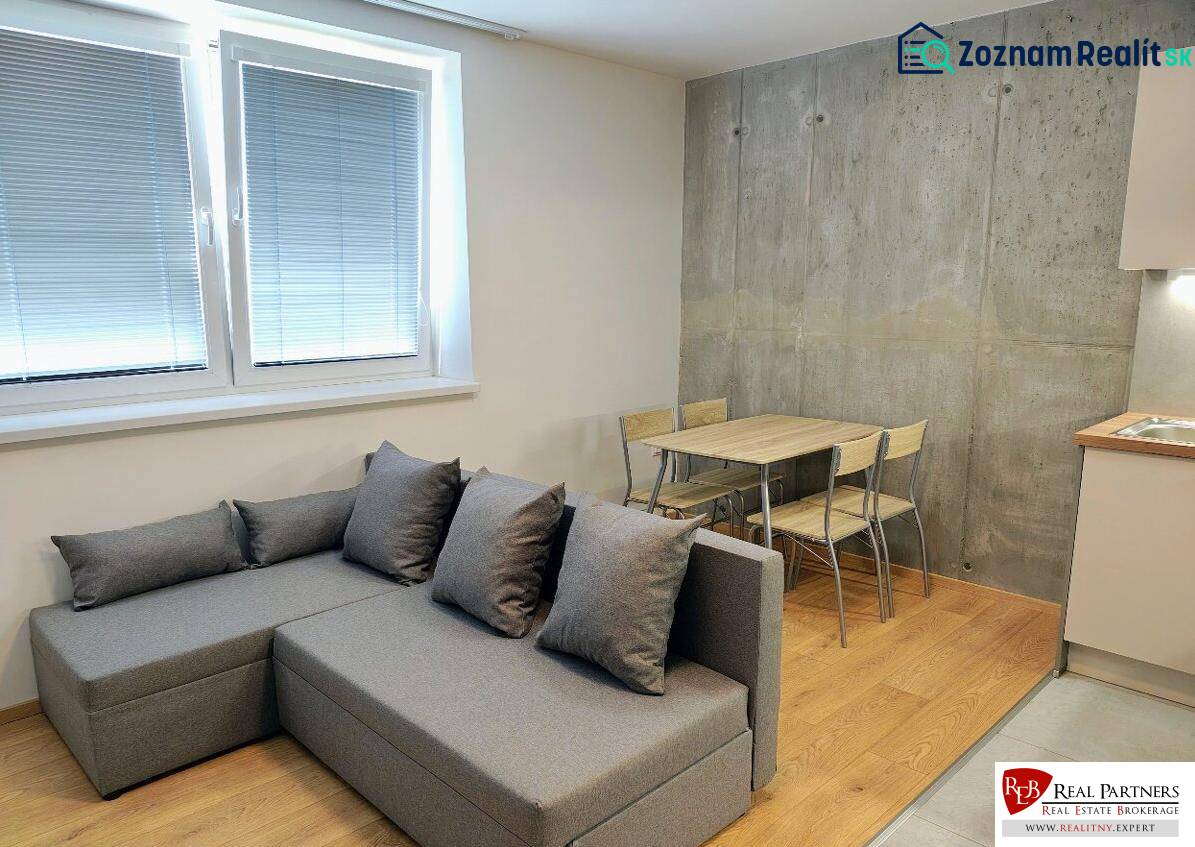 Gray sofa and dining area on a wooden decor floor in a 3-room apartment.