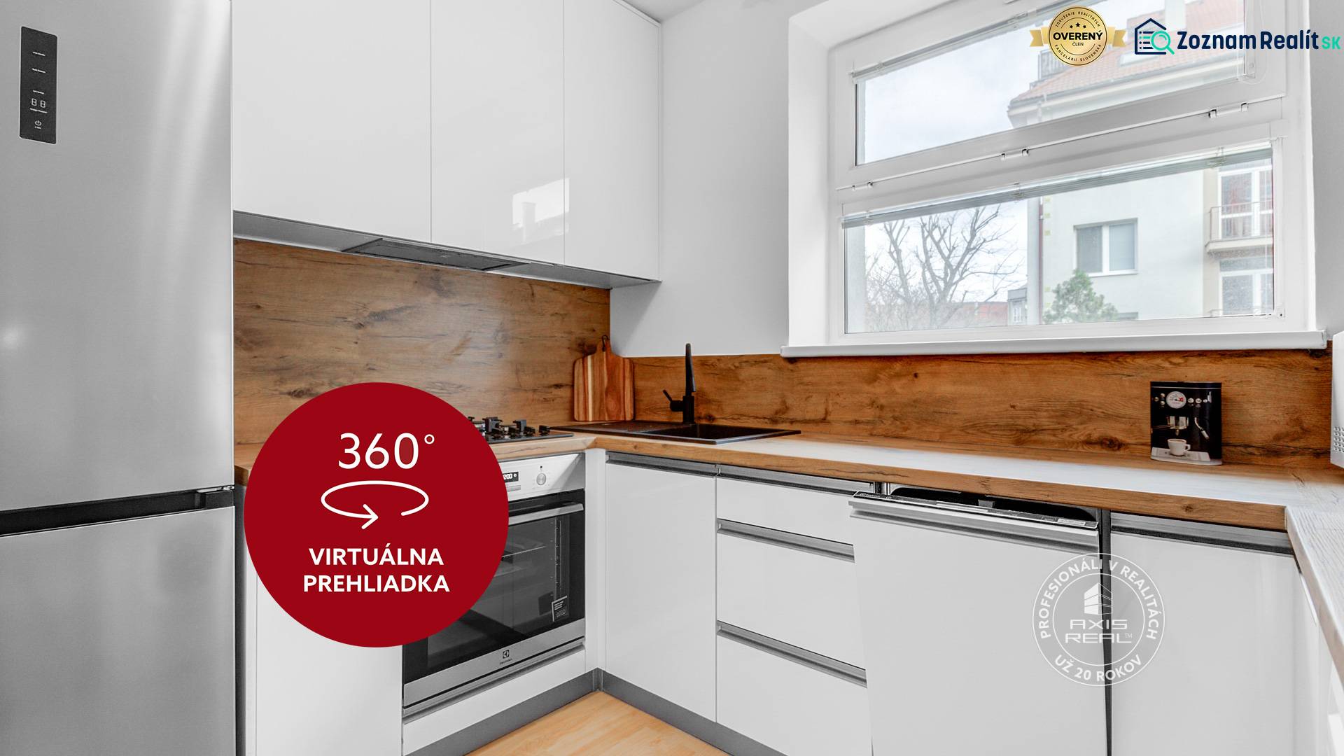 A kitchen with wood-patterned flooring in a 2-room apartment, white furniture, large window.