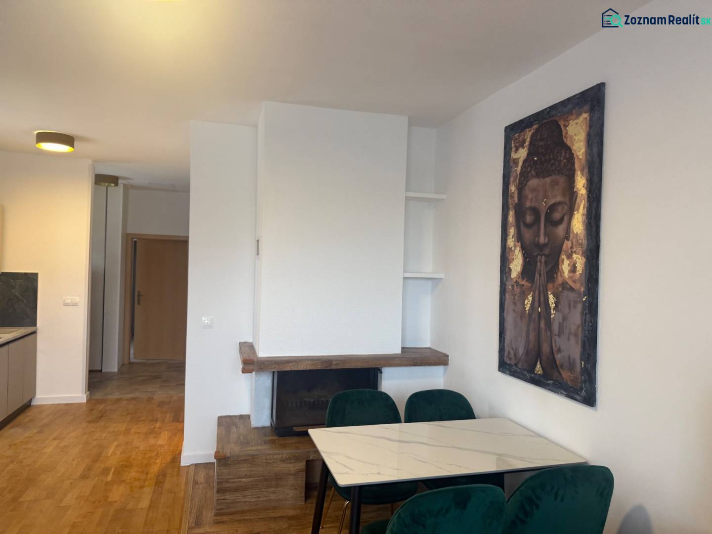A dining room in a family house with an art painting, a fireplace, and a wooden decor floor.