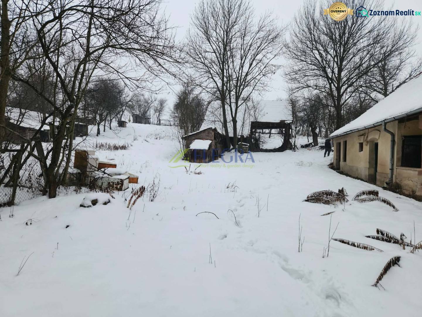 A snowy yard of a family house in Felsőtelekes with visible wooden structures.