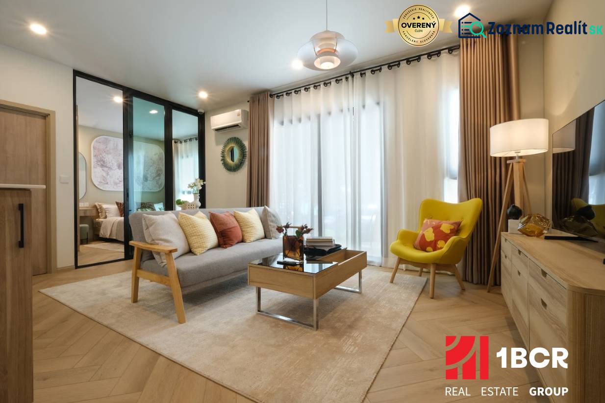 Living room of a two-room apartment with a wooden-patterned floor and comfortable furniture.
