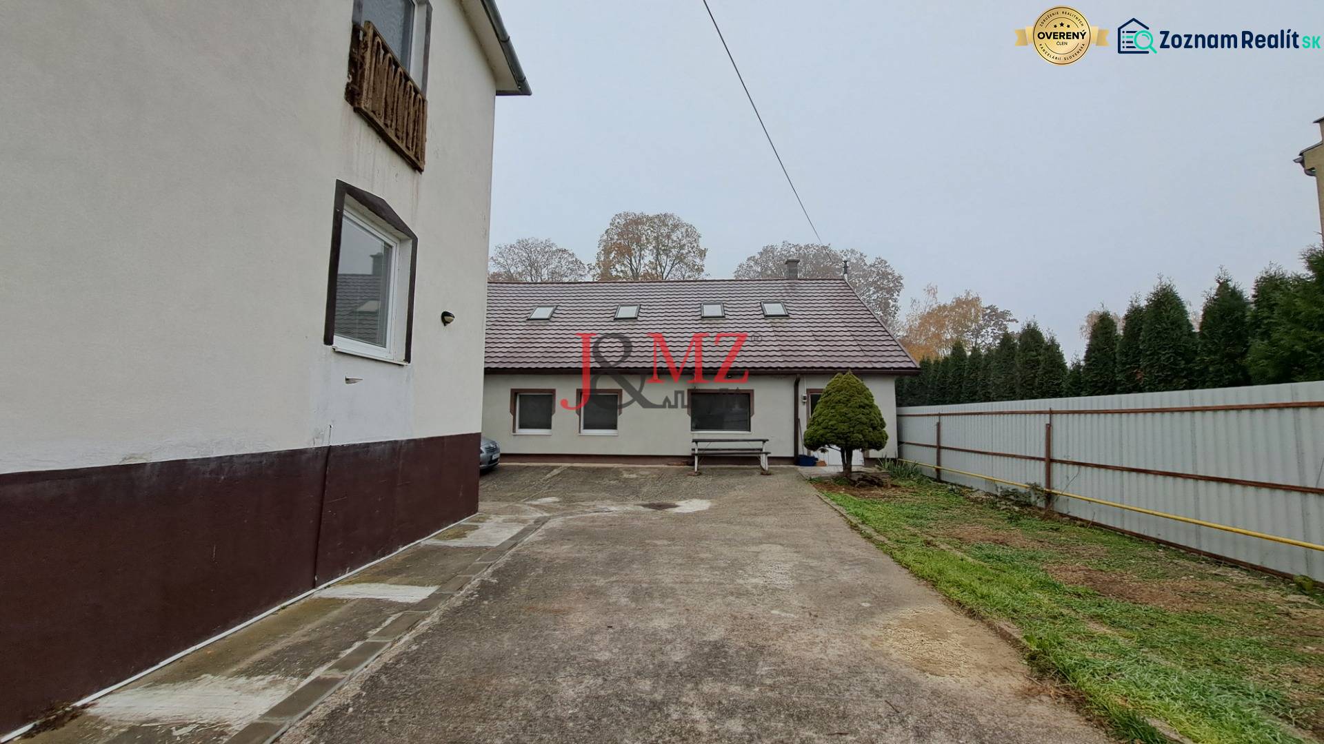 A family house in Kalná nad Hronom with a paved courtyard, greenery, and fencing.