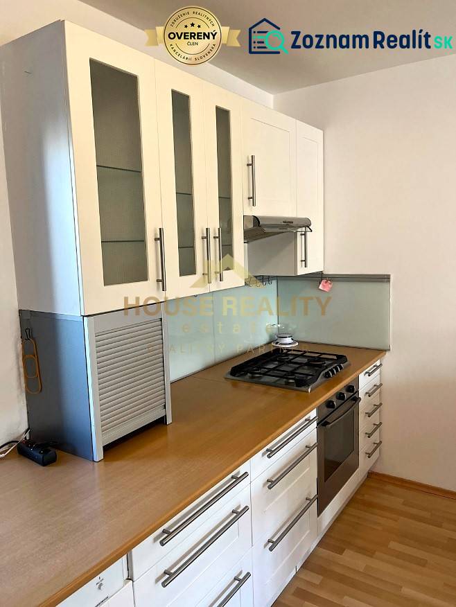 A kitchen in a 3-room apartment with a gas stove and a floor with a wooden decor.