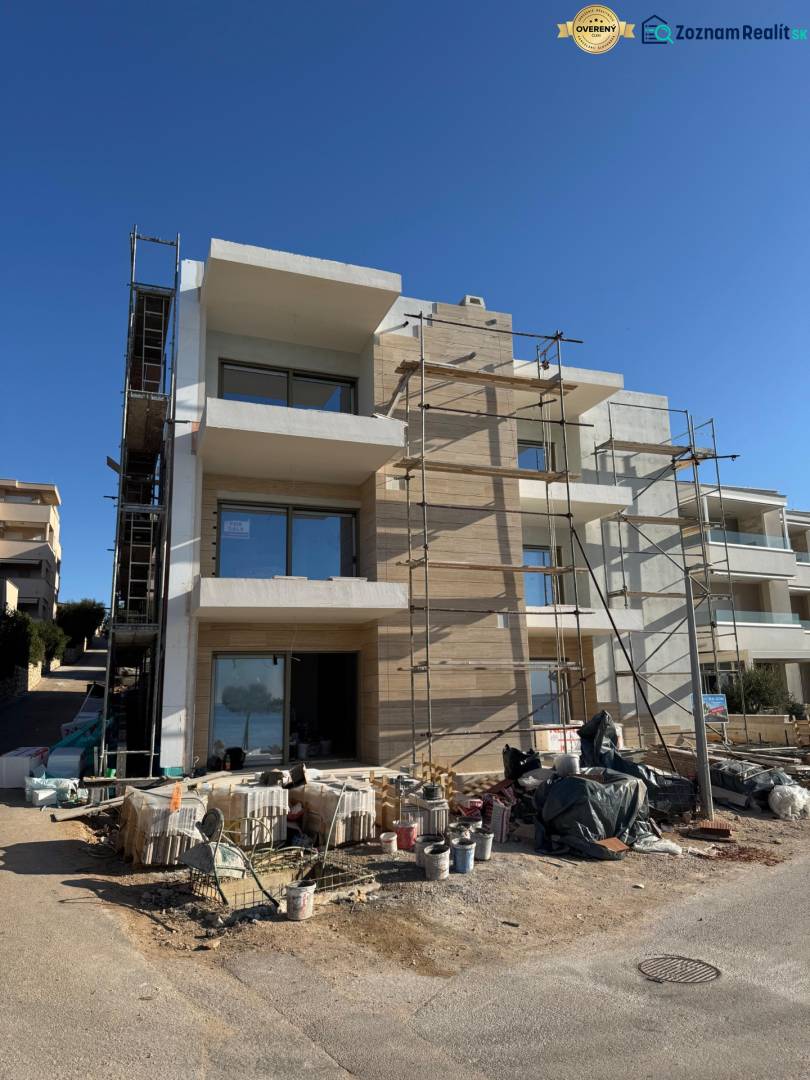 A new building in Mandre with 2-bedroom apartments, unfinished facade, scaffolding, and construction materials.