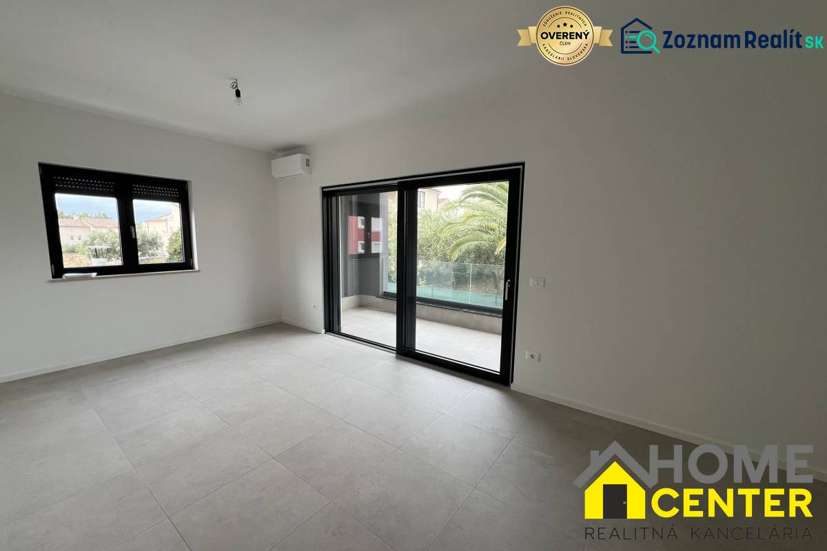 Recreational apartment with large windows, tiled floor, view of the terrace with palm trees.