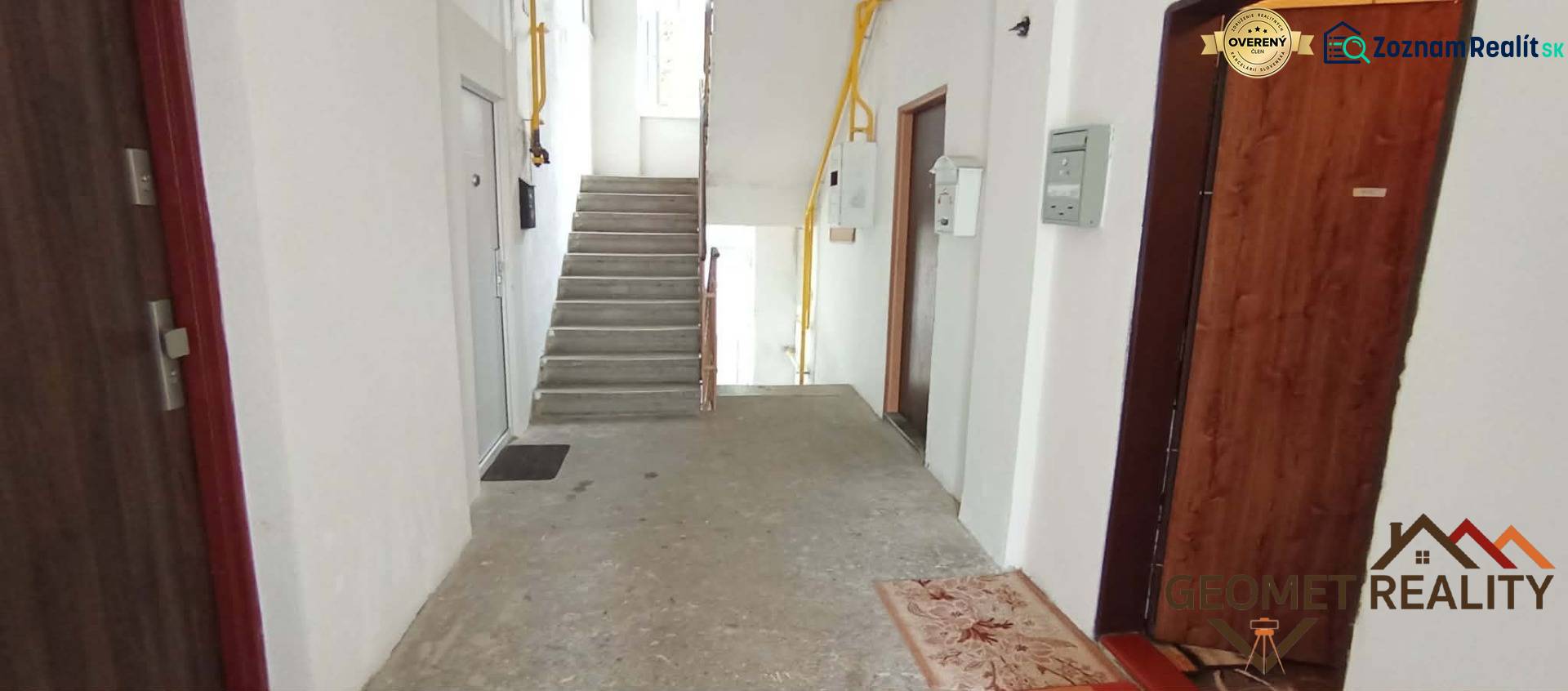 A corridor with concrete stairs and entrances to 2-bedroom apartments on Partizánska Street in Lučenec.