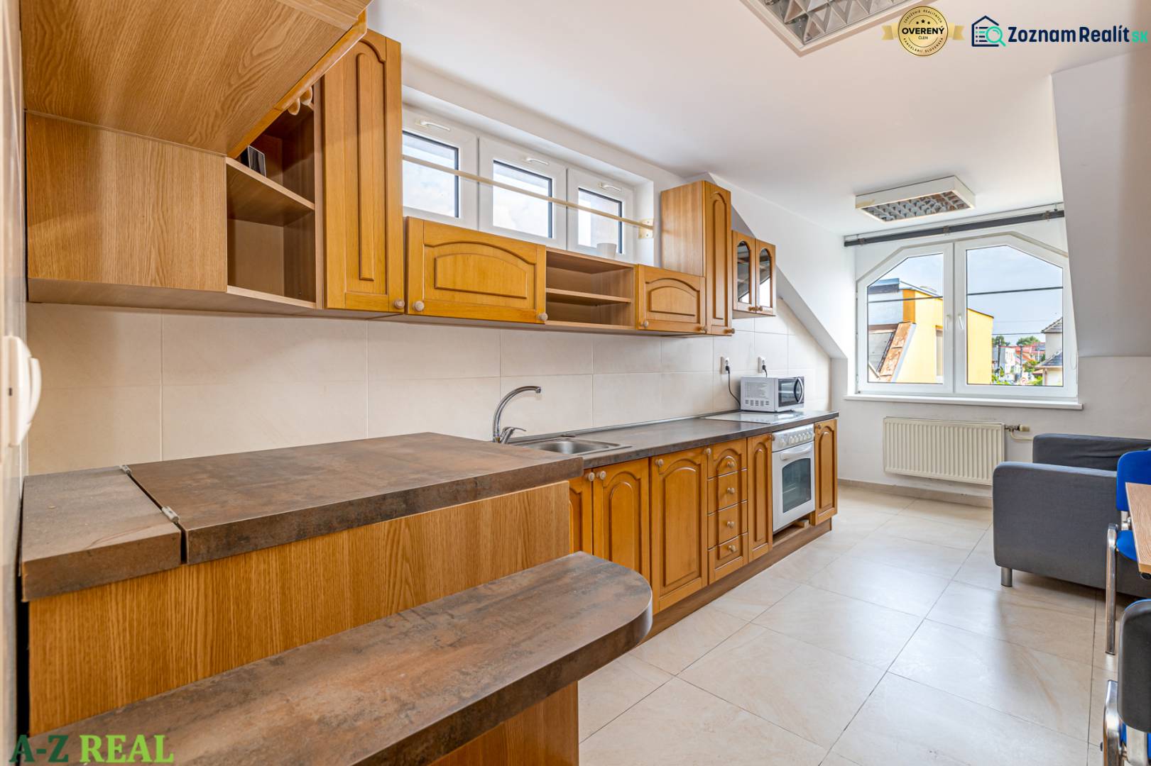 A kitchen unit in a family house with windows, space for both a microwave and an oven.