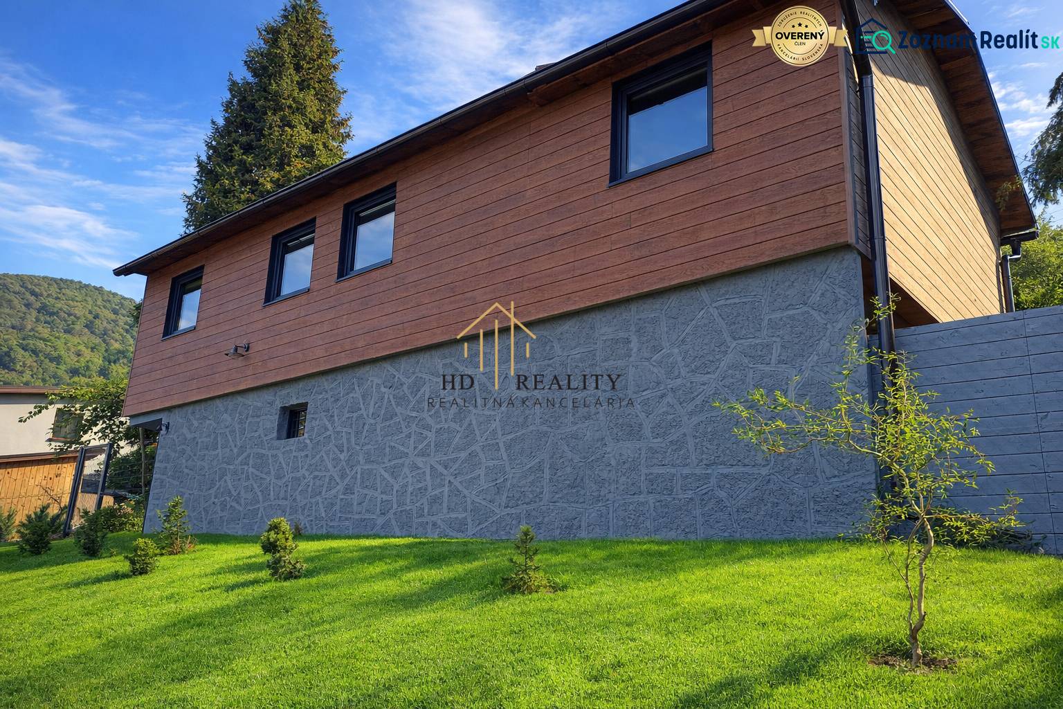 A cottage in the town of Zvolen with a stone and wooden facade surrounded by a manicured lawn.