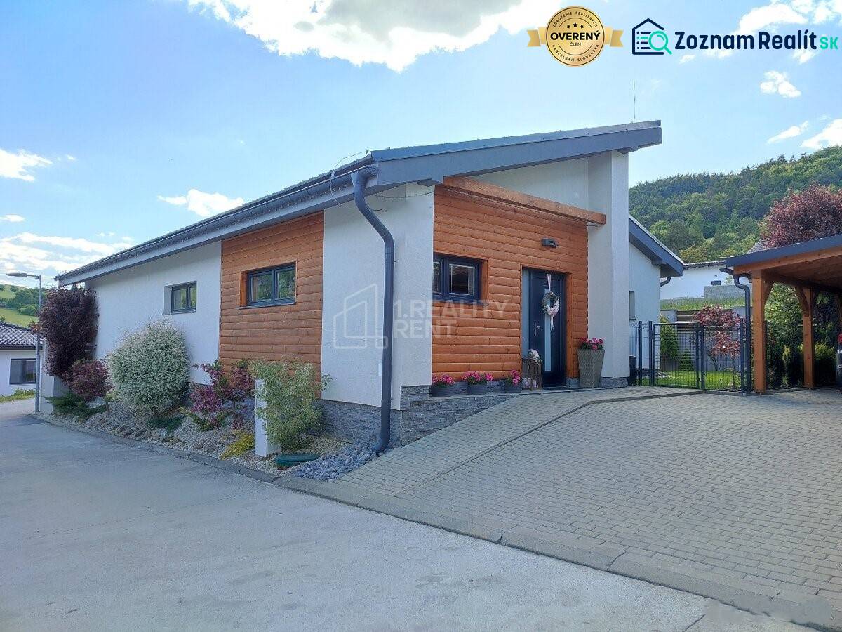 A family house in Kotrčiná Lúčka with wooden cladding and a garden, surrounded by nature.