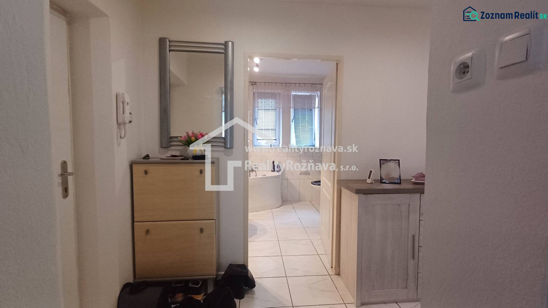 Interior of a 2-room apartment with a mirror, shoe cabinet, and view of the bathroom.