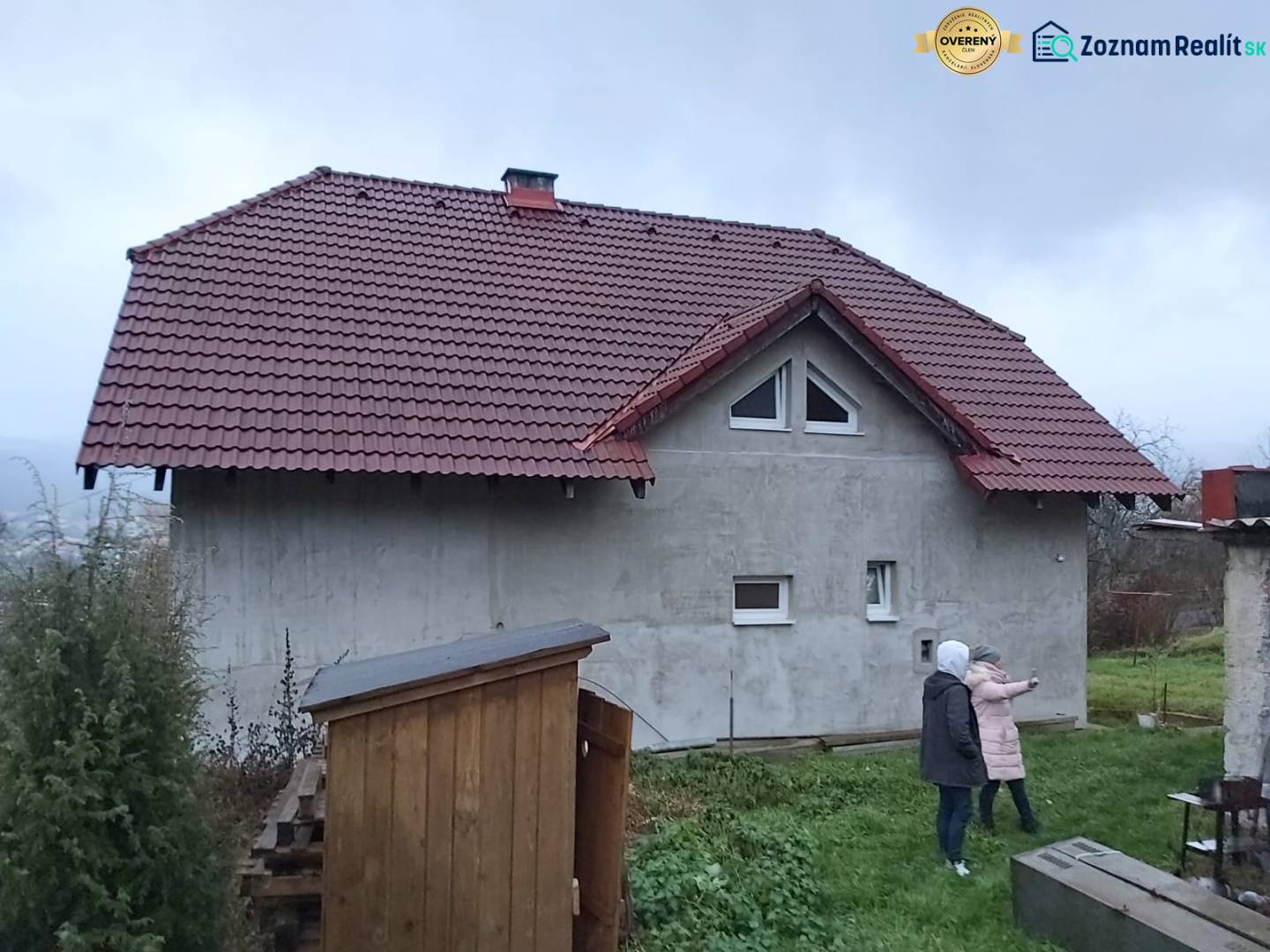 A family house in Orovnica, gable roof, two people on the lawn.