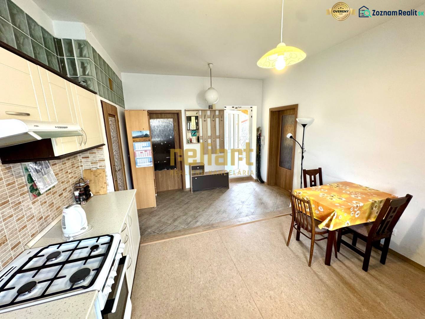 A kitchen in a 2-room apartment with a dining area and a wooden decor floor.