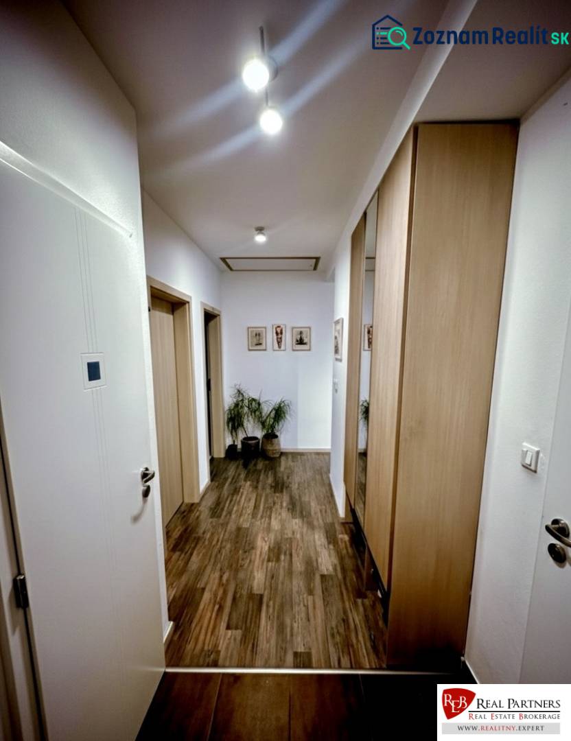 A hallway in a 3-room apartment with a wooden decor floor and built-in wardrobes.