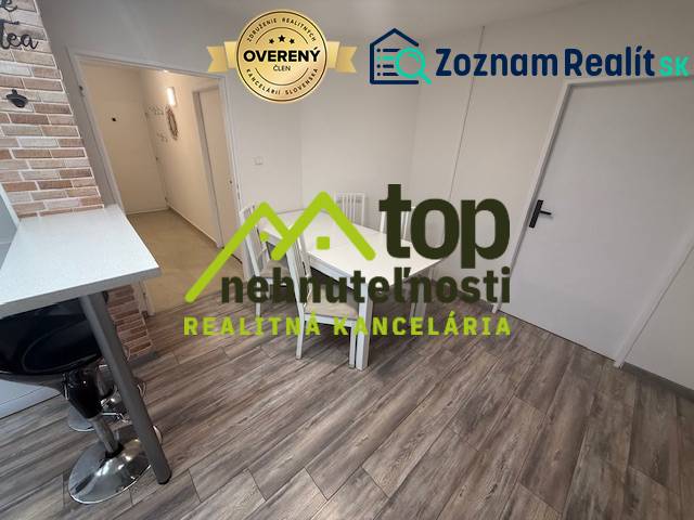 A one-room apartment with a wooden decor floor and a dining table.