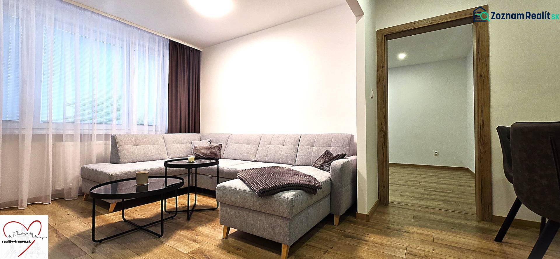 Living room with a comfortable sofa and a wooden-patterned floor in a 3-room apartment.