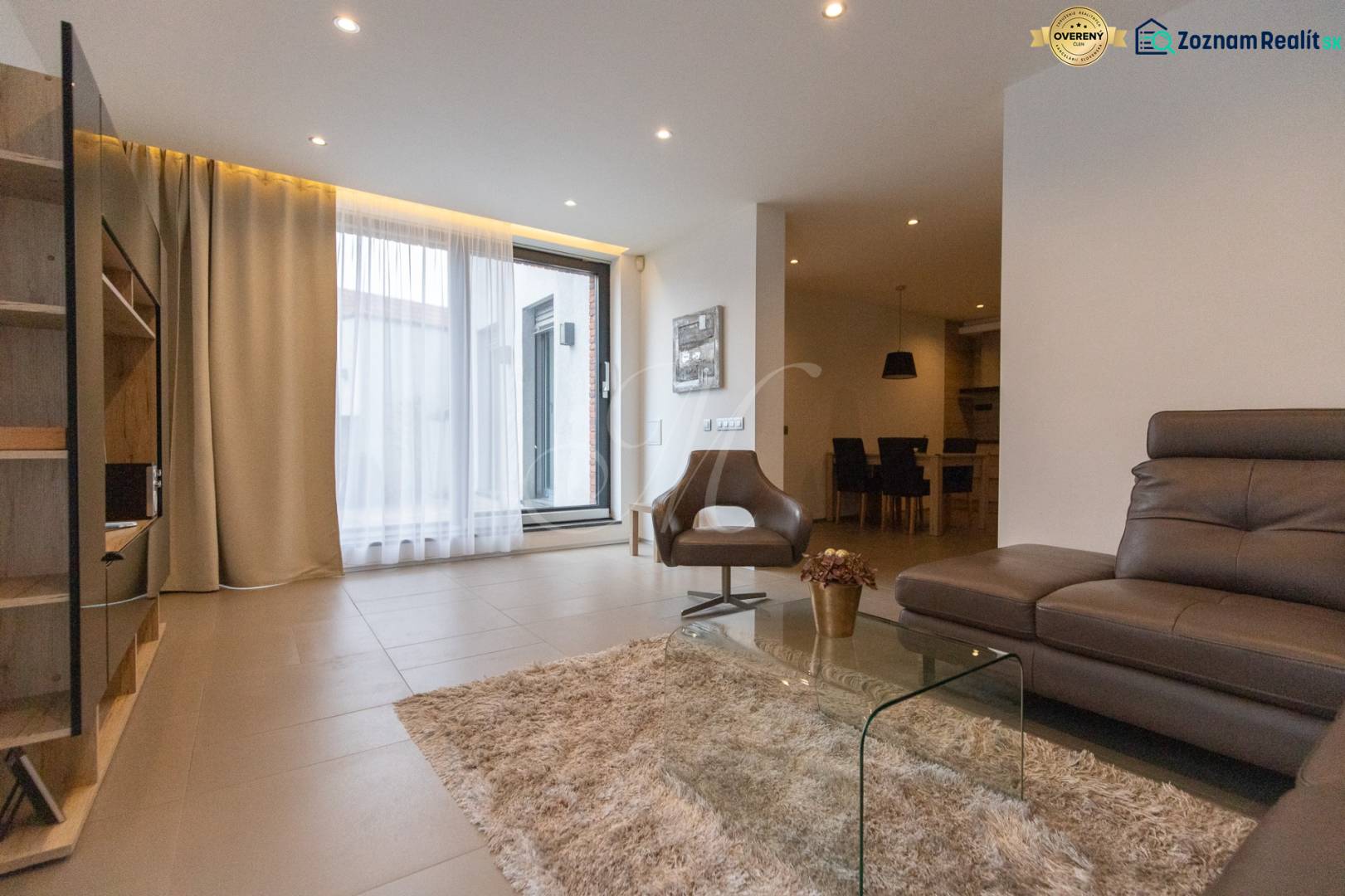 Living room in a two-room apartment with a comfortable sofa, an armchair, and a glass table.