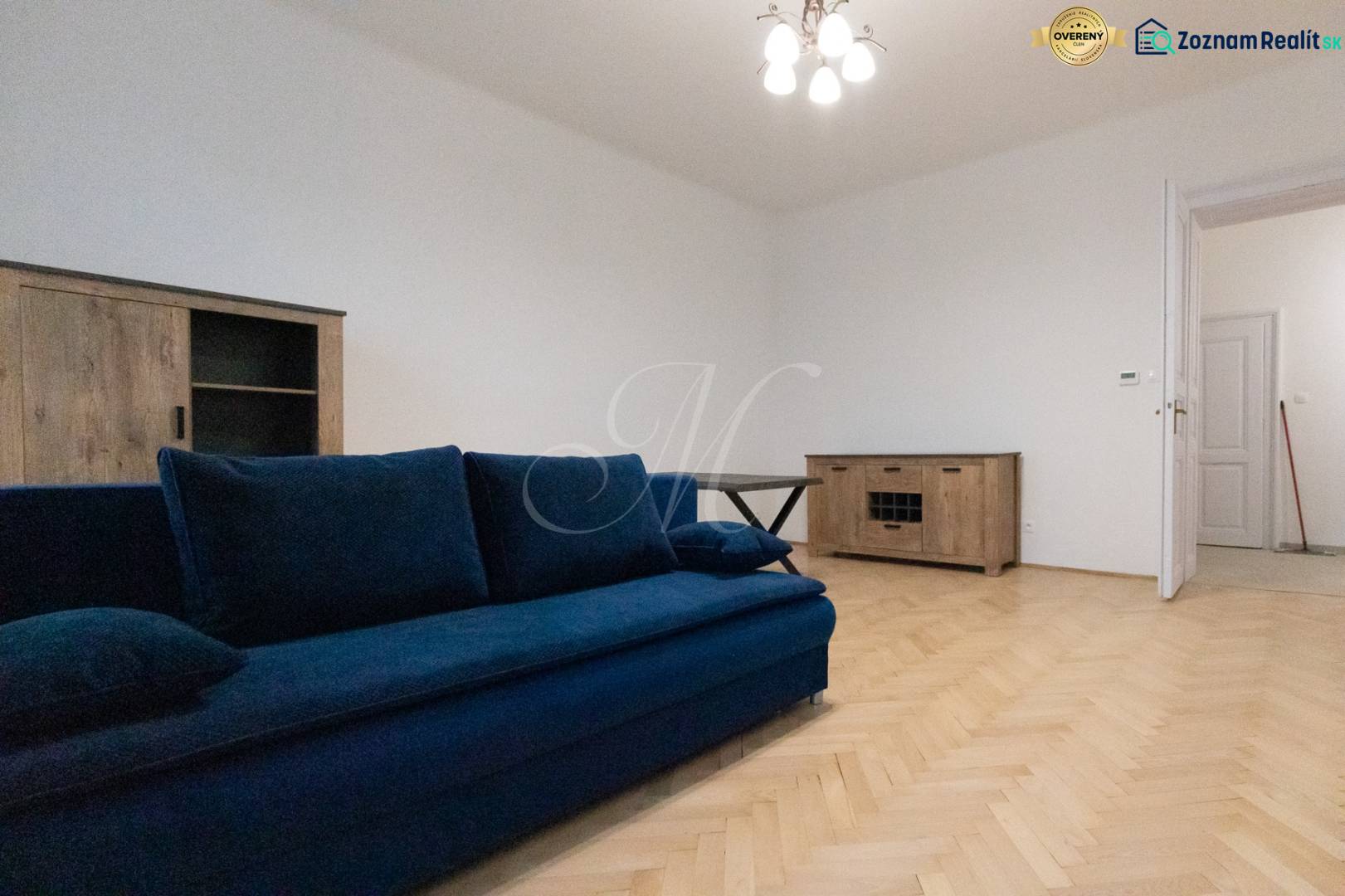 A room with a blue sofa and wooden floor decor in a 3-room apartment.