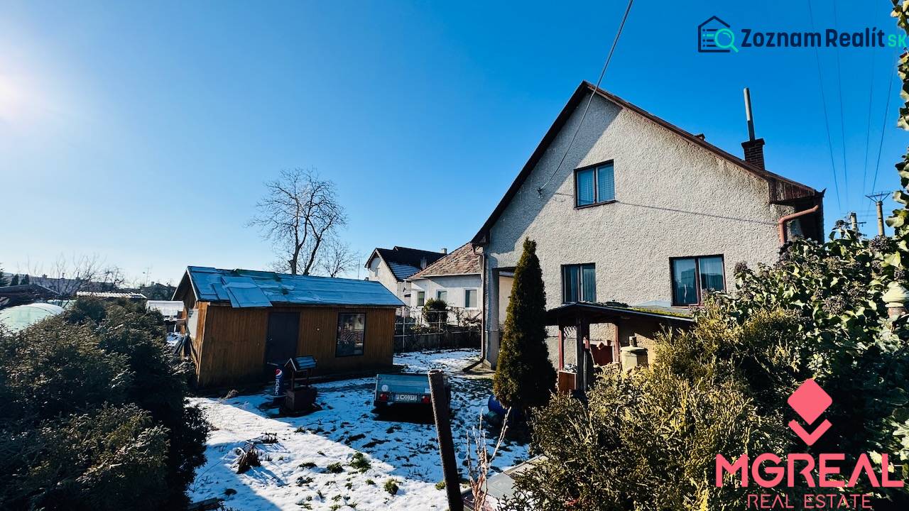 Pitched roof, adjacent shed, and snow-covered garden at a family house in Partizánske, in Veľké Bielice.