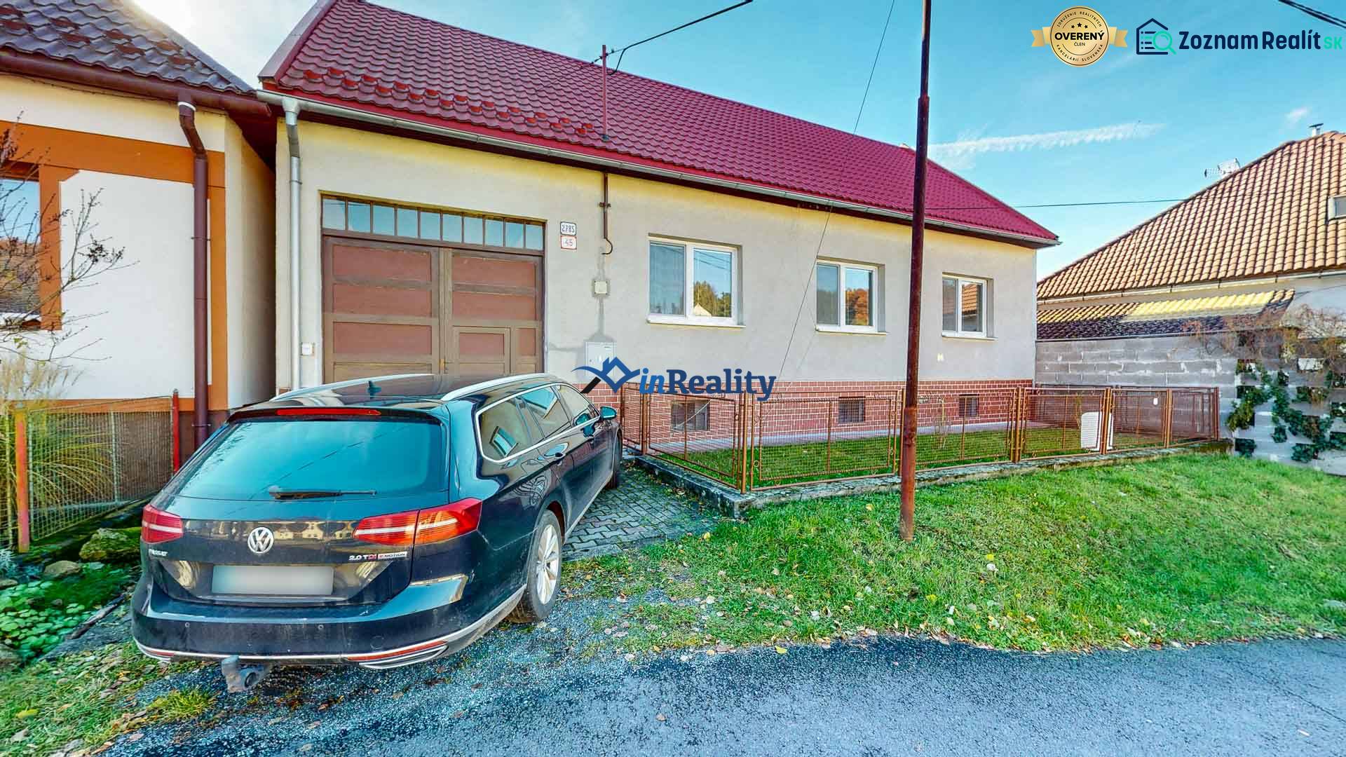 A family house in Lieskovec with a spacious garage and a car on a paved area.