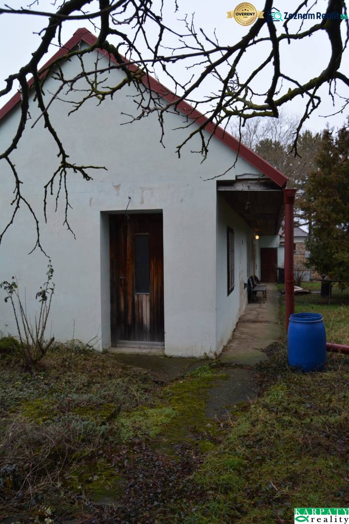 A family house in Abrahám with a courtyard, a blue barrel, and wooden doors.