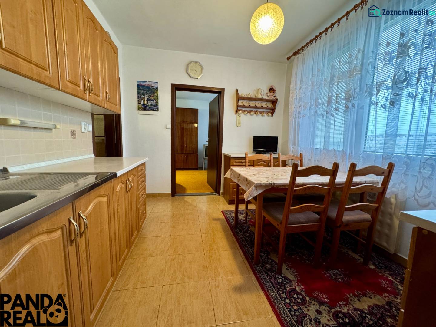 A kitchen in a 3-room apartment with a dining table, floor with wood decor.