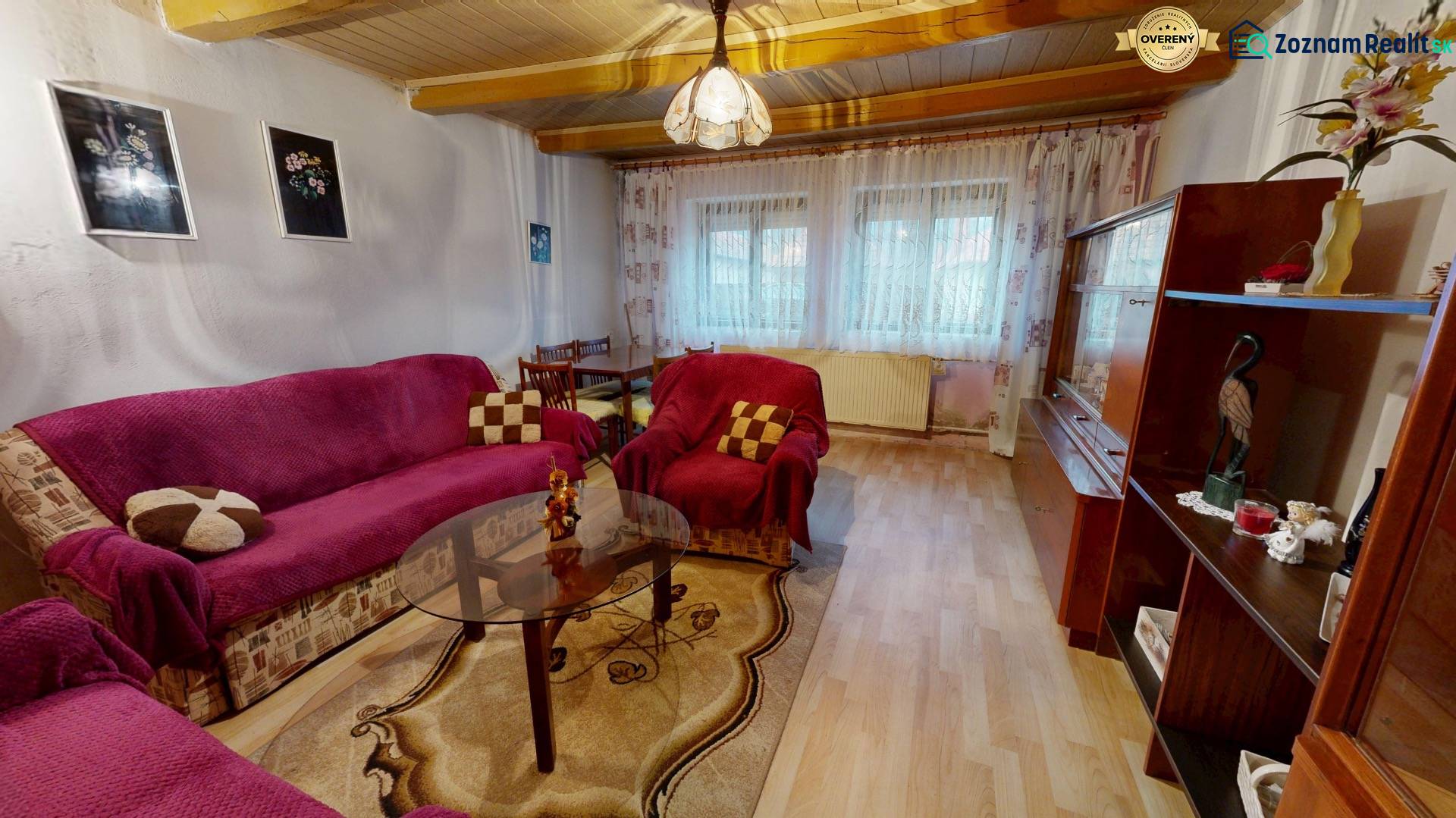 The interior of a living room in a family house with a blanket on the sofa and a floor with a wooden decor.