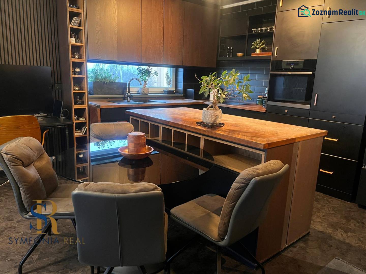 A kitchen in a 2-room apartment with black cabinets and a wood-patterned floor.