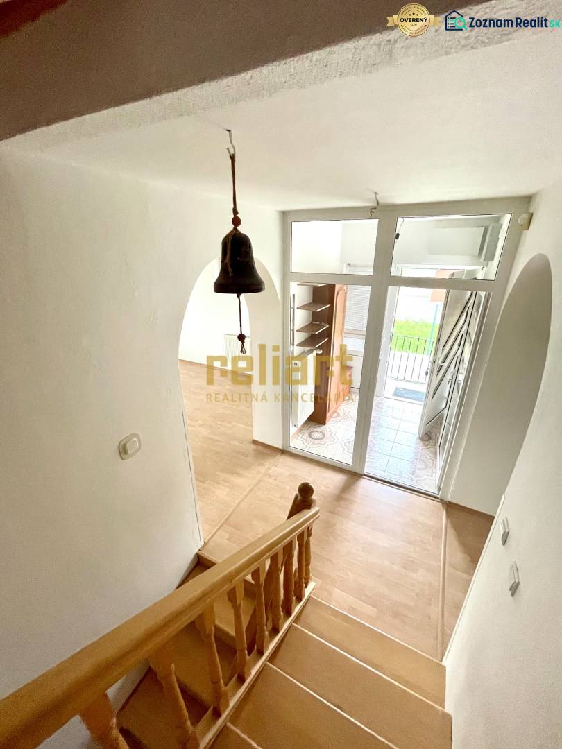 Staircase with a wooden decor floor, entrance door, and doorbell in a family house.