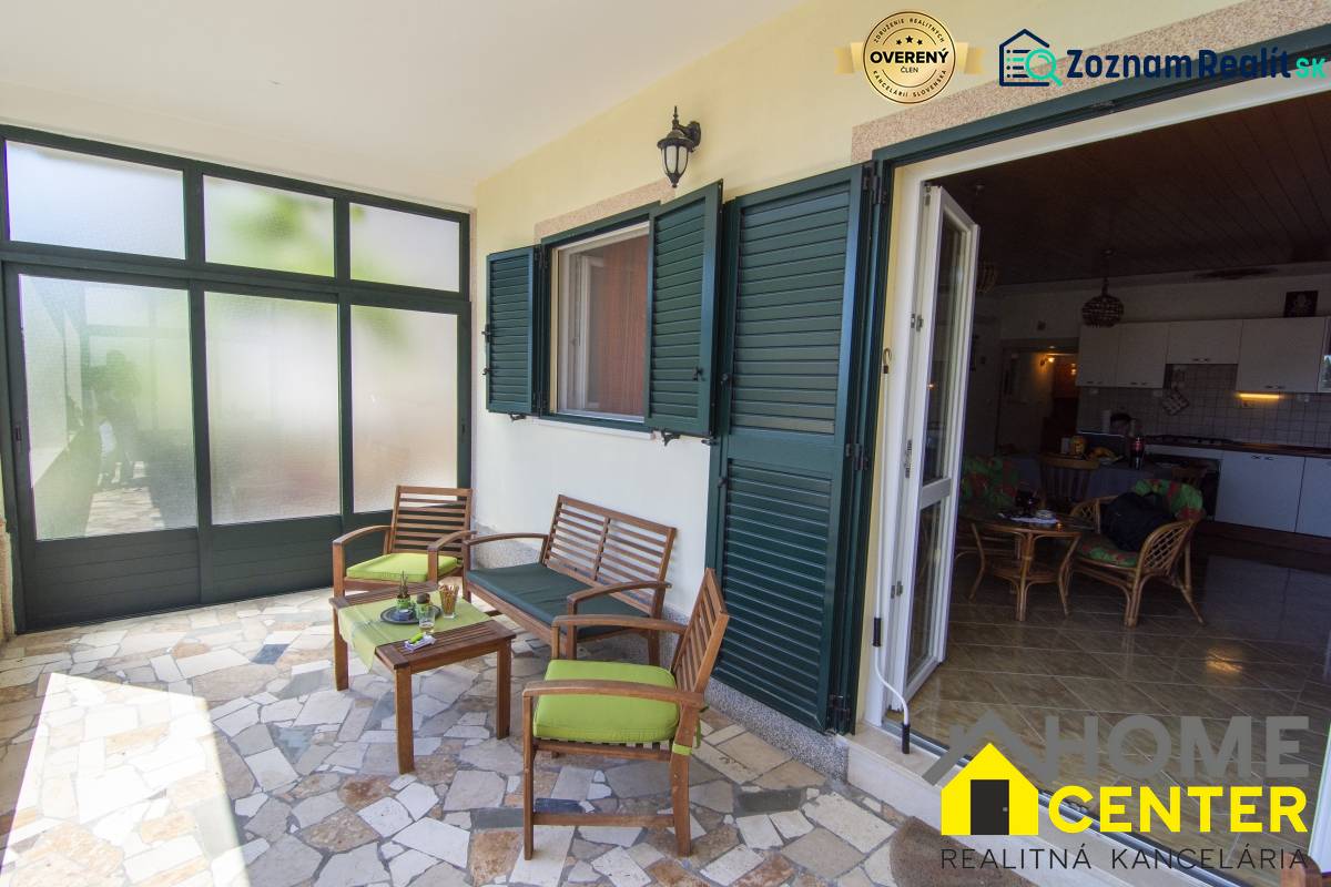 Terrace of a recreational apartment in Čiovo with comfortable seating and a view of the interior.