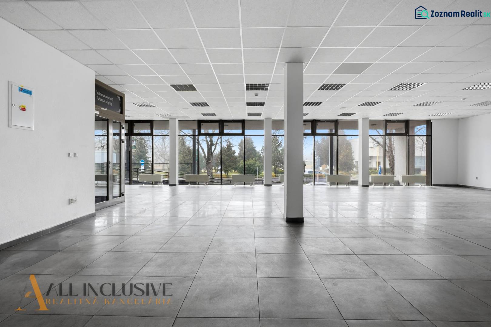 Spacious commercial spaces with large windows, light tiles, and columns.