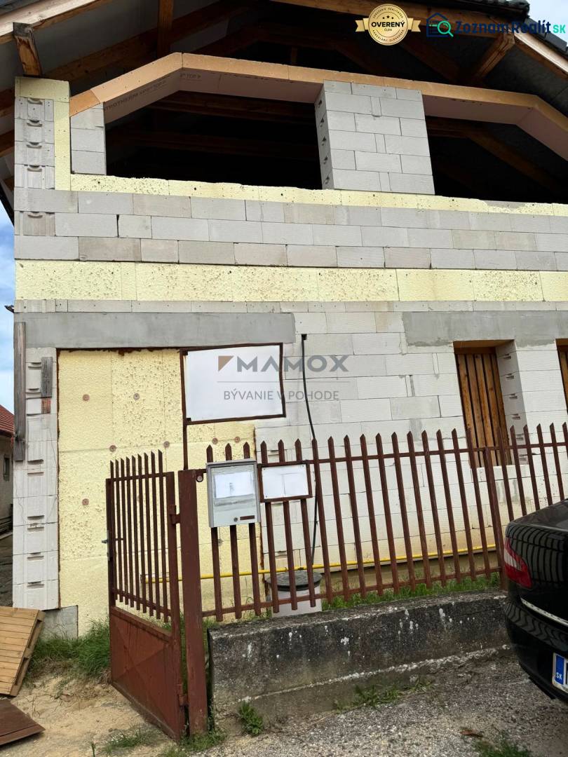 Unfinished family house in Nitrianska Chrenová, two floors with yellow insulation and a fence.