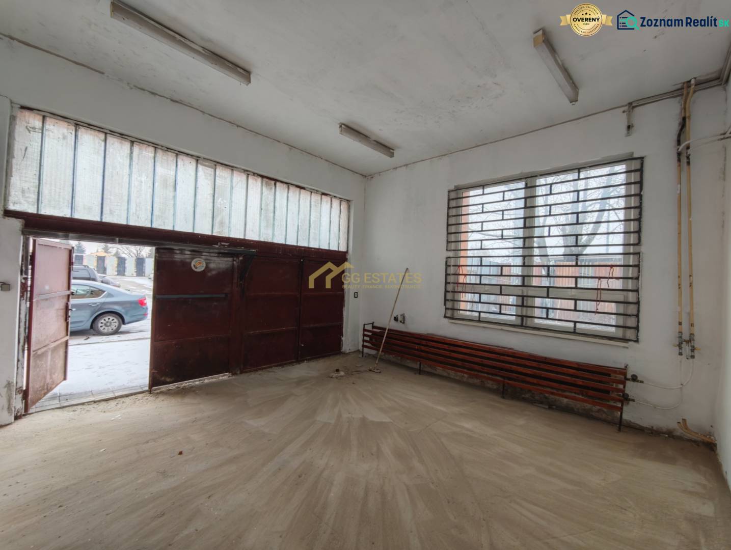 Interior of a garage with a wooden decor floor and a metal gate.