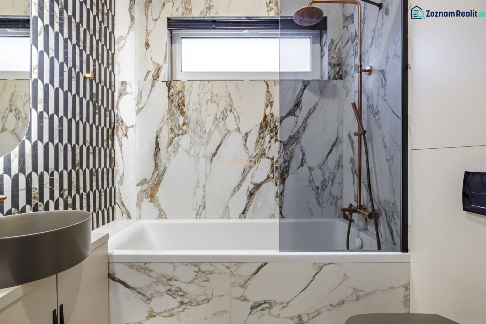 A bathroom in a 2-room apartment with designer tiles and a bathtub in a marble decor.