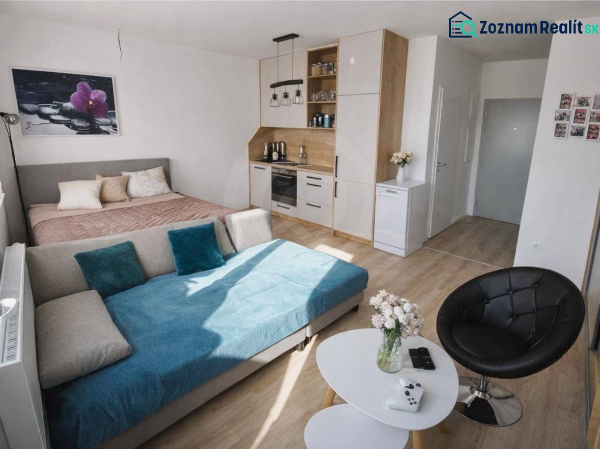A one-room apartment with a bed, a sofa, a kitchenette, and a floor with a wooden decor.